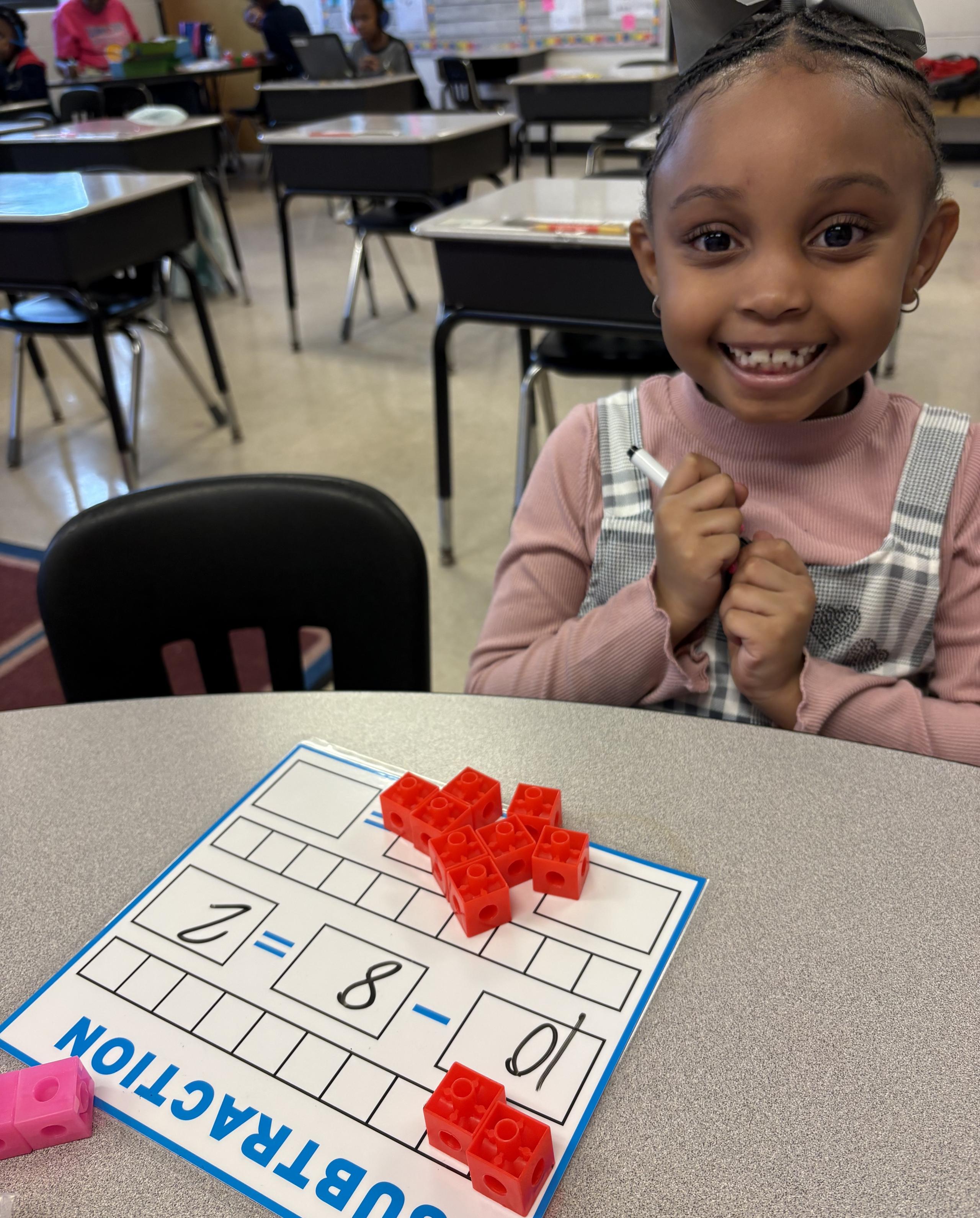 Student Smiling with Number Card/Blocks